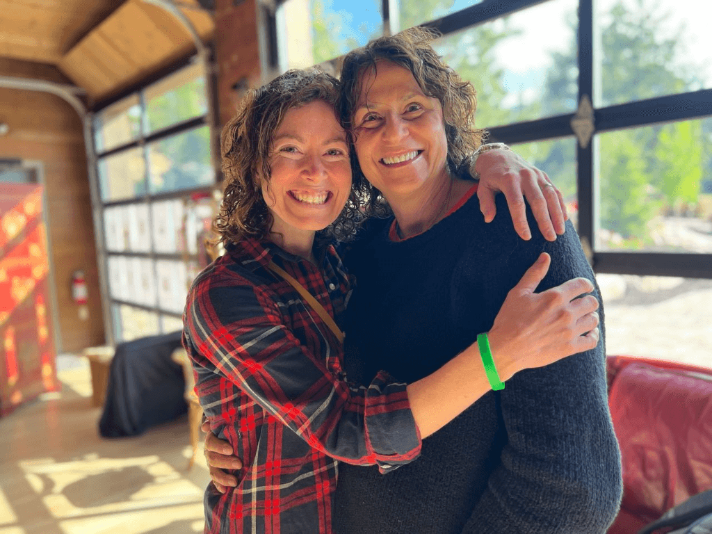 Two campers embracing and laughing in a sunlit room